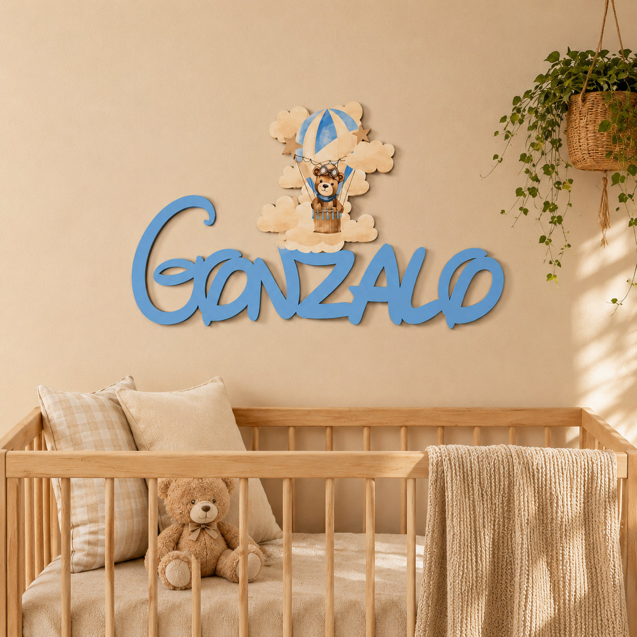 Nombre de madera personalizado colocado sobre la cuna decorando una habitación de bebé.