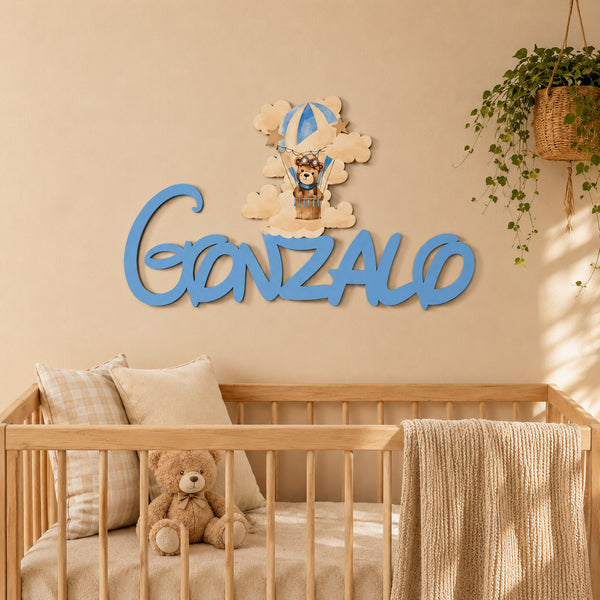 Nombre de madera personalizado colocado sobre la cuna decorando una habitación de bebé.
